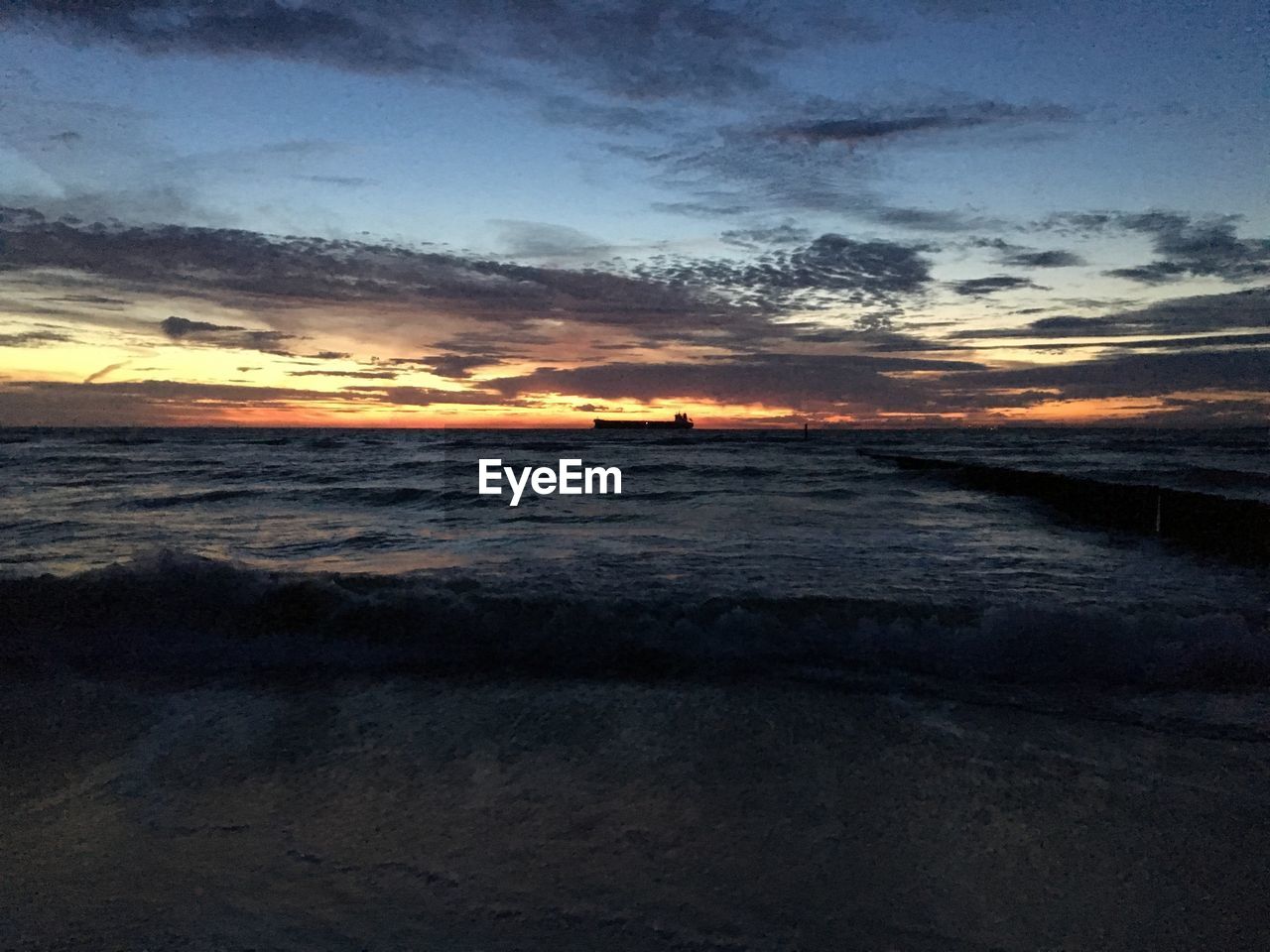 SCENIC VIEW OF BEACH AGAINST SKY AT SUNSET