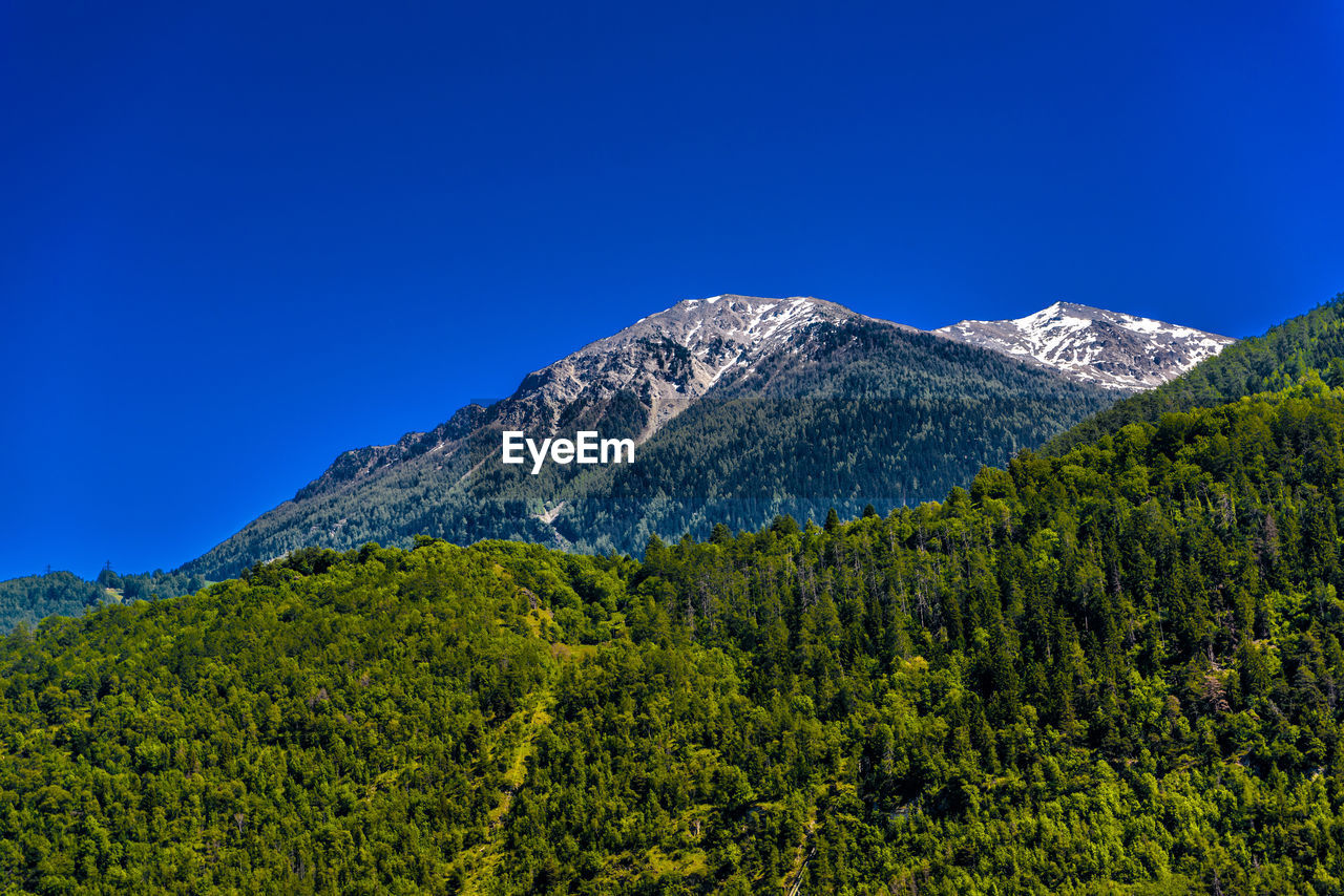 Scenic view of mountains against clear blue sky