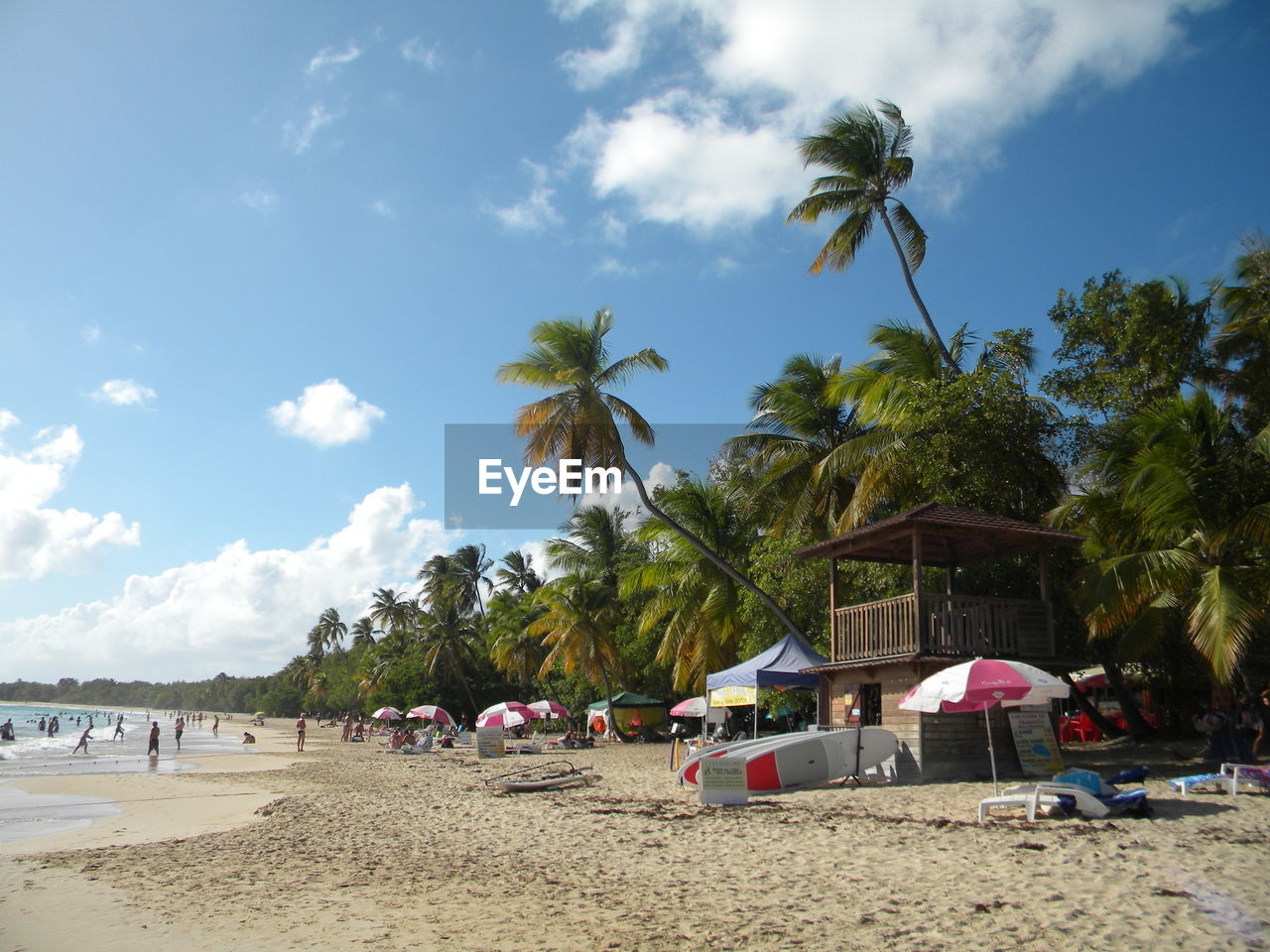 People enjoying at beach against sky