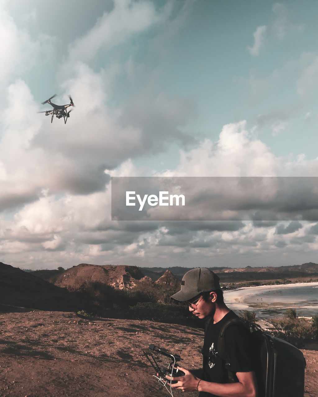 Man flying drone while standing outdoors