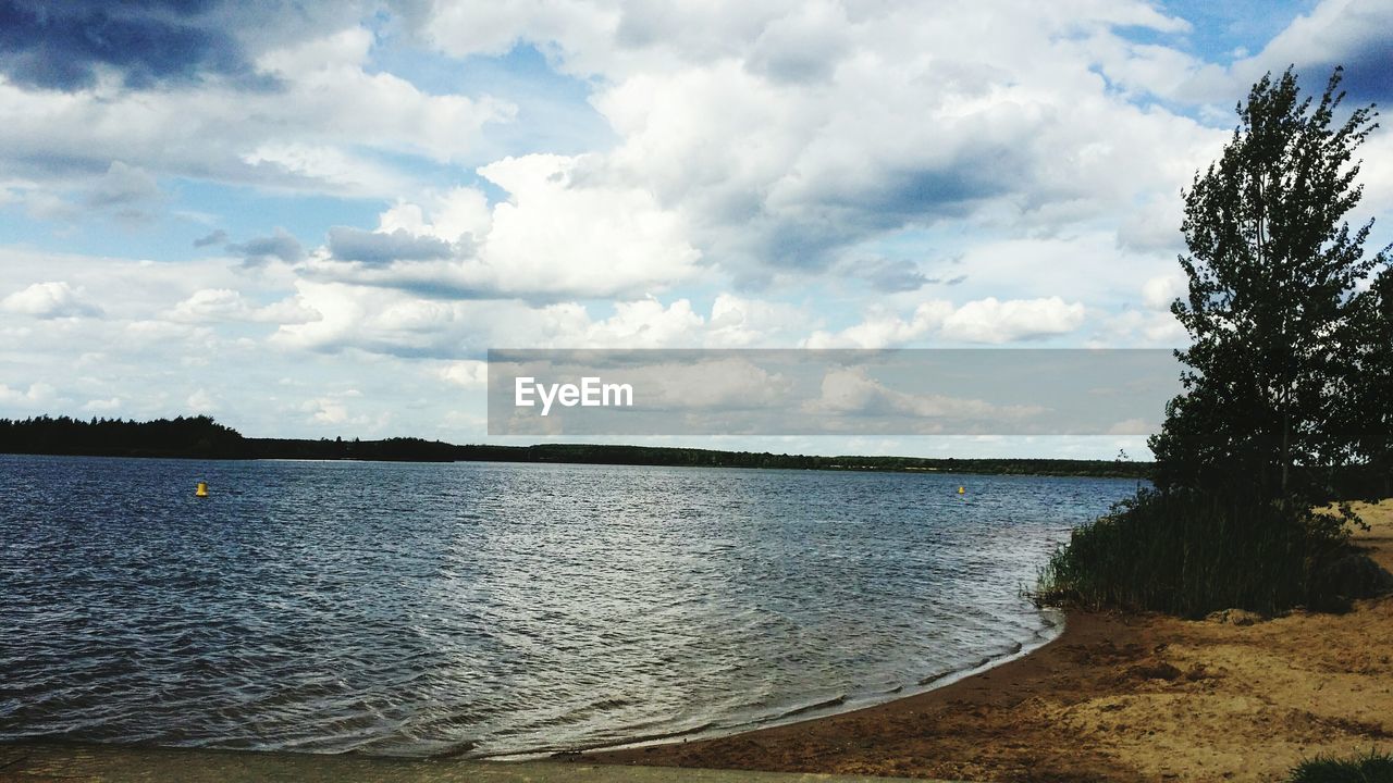 SCENIC SHOT OF CALM LAKE AGAINST CLOUDY SKY