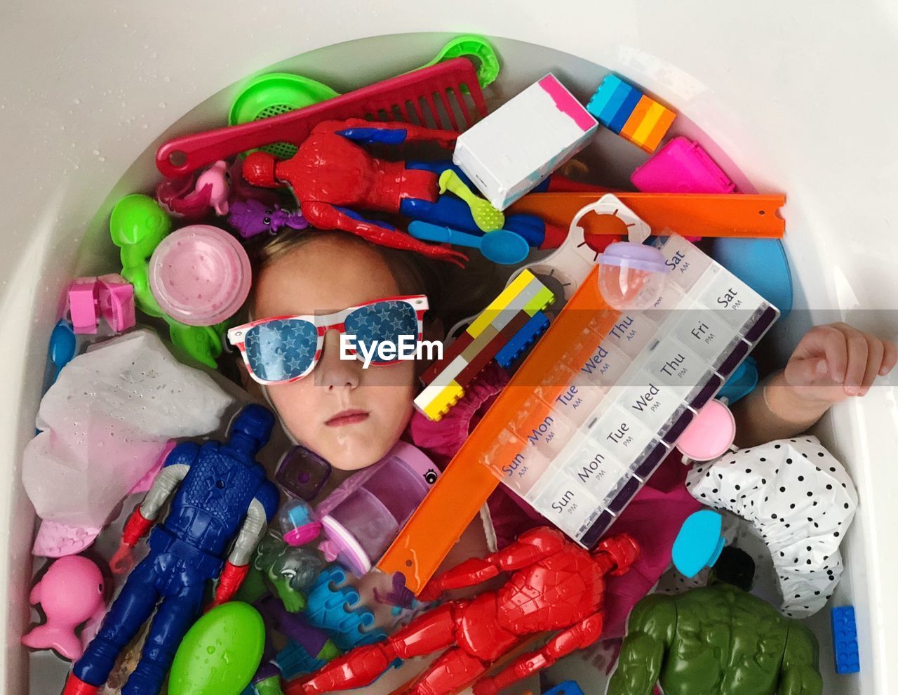 HIGH ANGLE VIEW OF CUTE GIRL WITH TOY TOYS