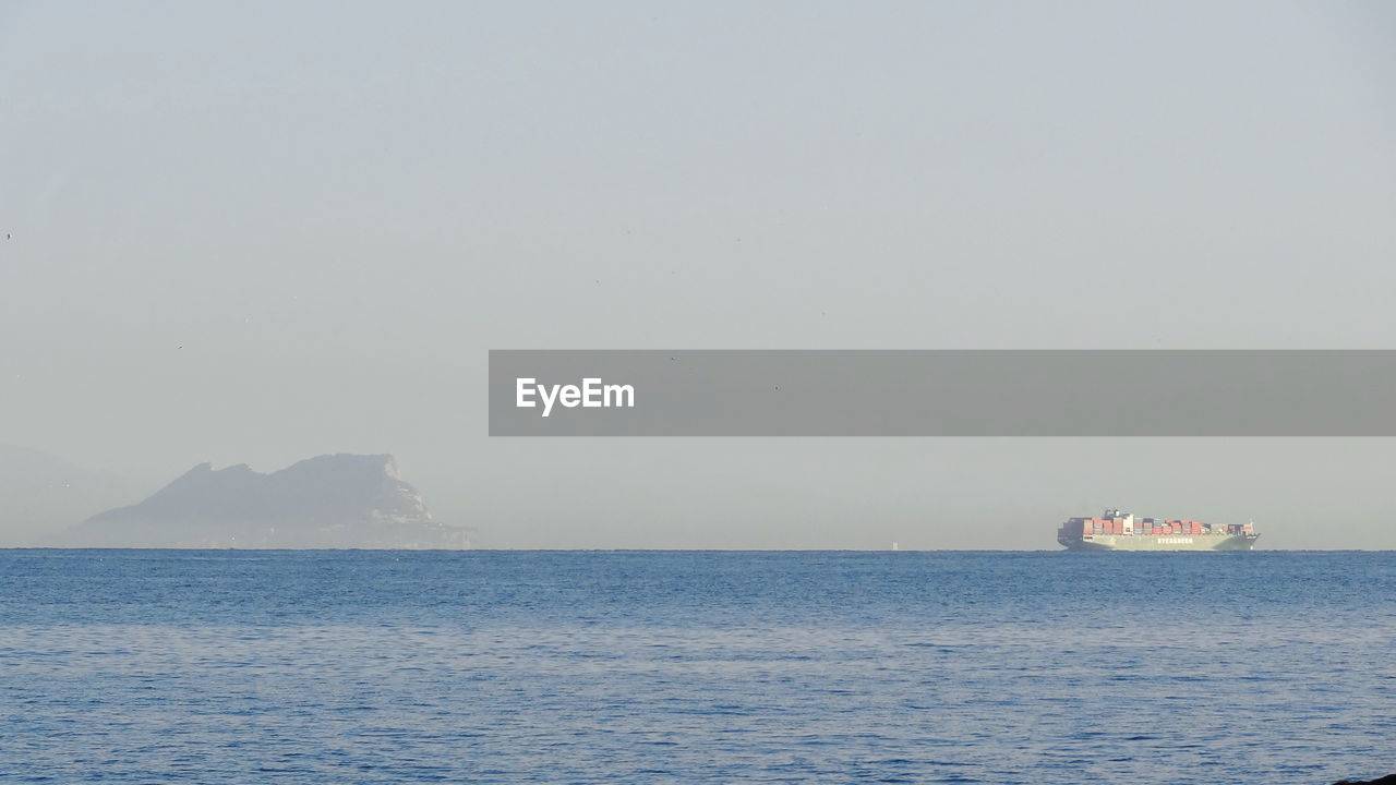 SHIP SAILING IN SEA AGAINST CLEAR SKY