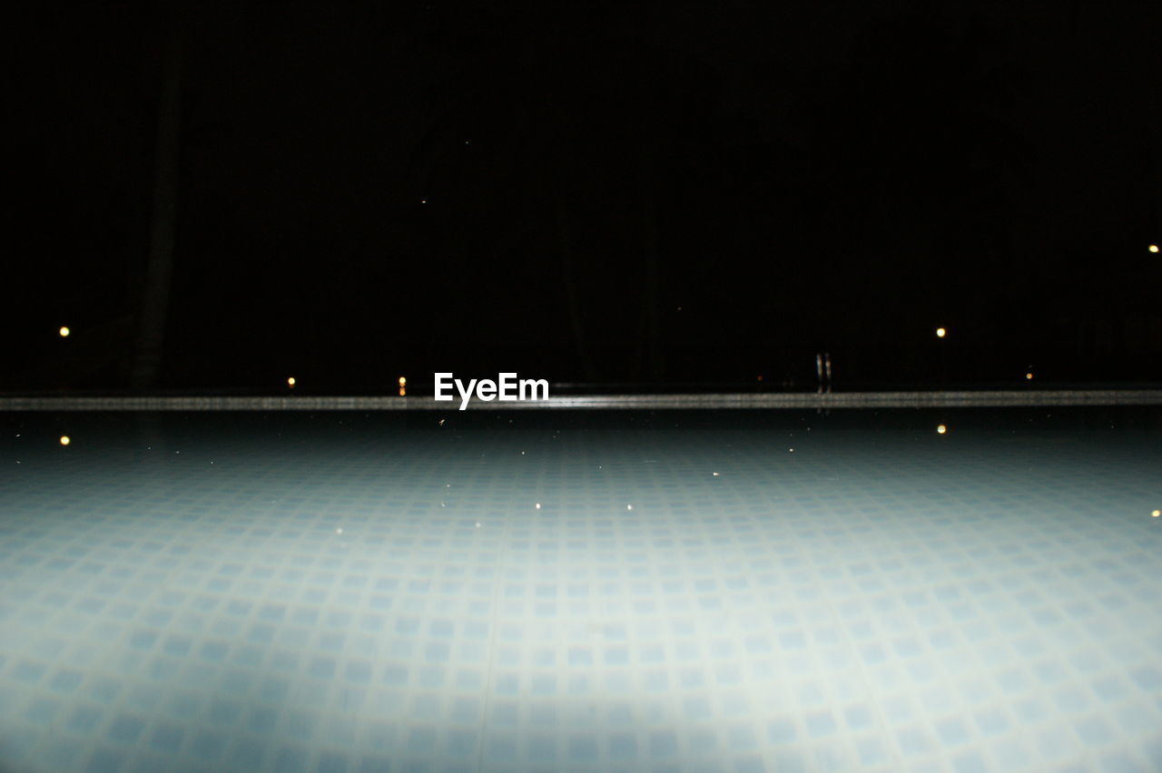 Swimming pool against clear sky at night
