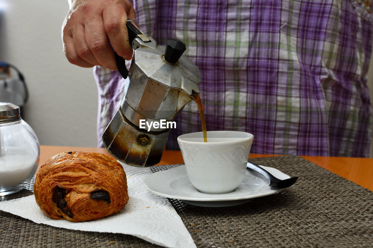 Breakfast desk with coffee cup, croissant and sugar pot