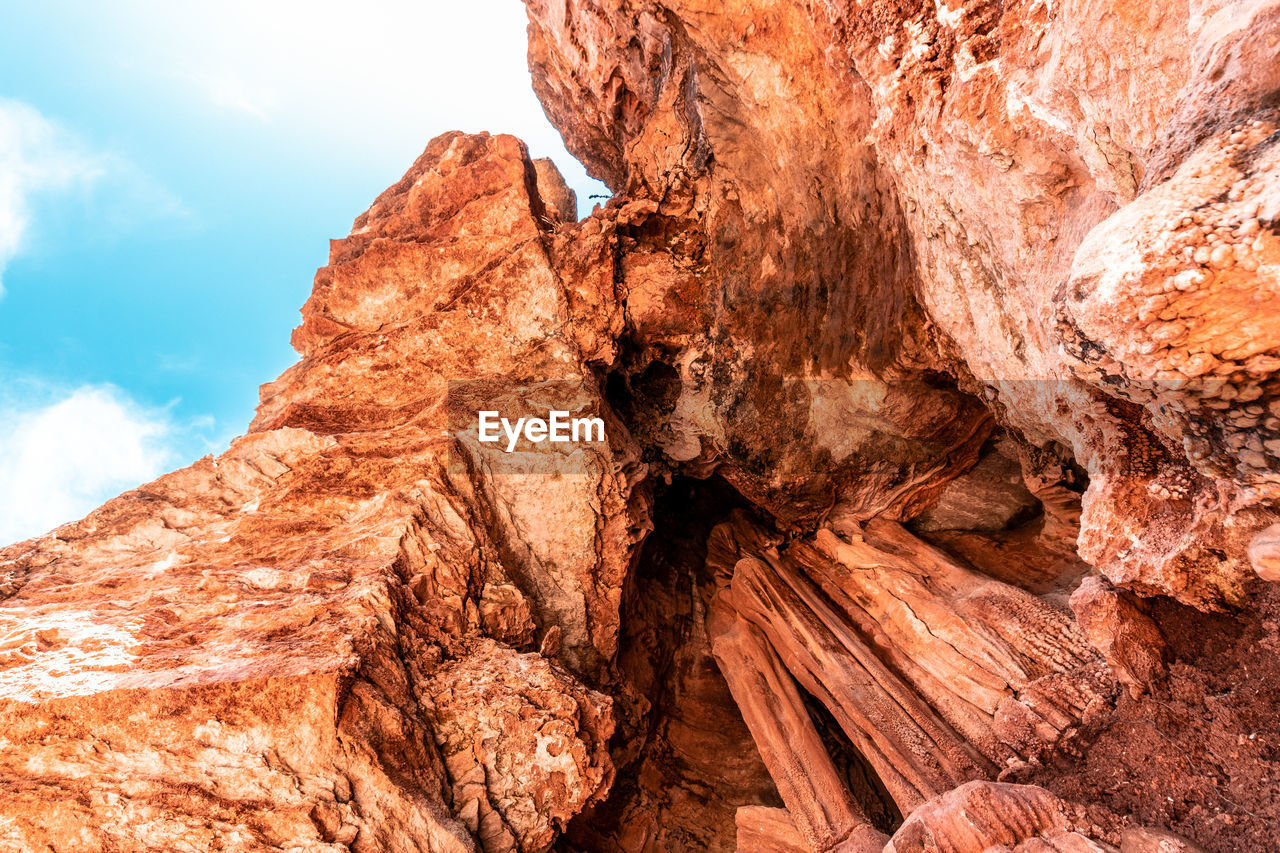 LOW ANGLE VIEW OF ROCK FORMATION AGAINST MOUNTAIN