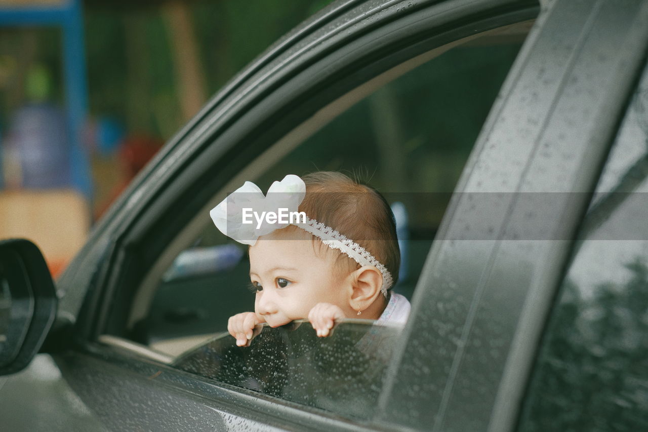 Little baby peeking outside car window 