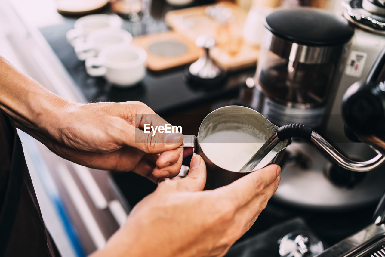 HIGH ANGLE VIEW OF MAN PREPARING FOOD IN KITCHEN