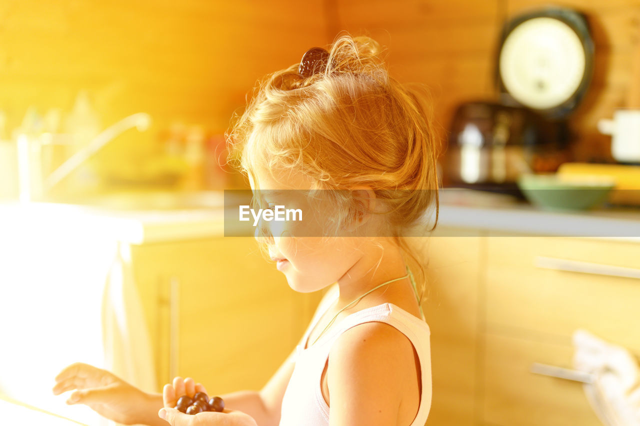 PORTRAIT OF A GIRL SITTING ON TABLE AT HOME