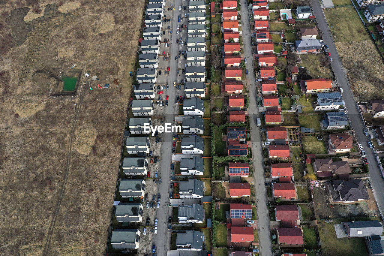 residential area, high angle view, aerial photography, architecture, transportation, neighbourhood, urban area, aerial view, mode of transportation, suburb, city, building exterior, built structure, metropolitan area, day, building, no people, motor vehicle, in a row, land vehicle, outdoors, tower block, car, nature, bird's-eye view, street, residential district, industry, vehicle, road, transport