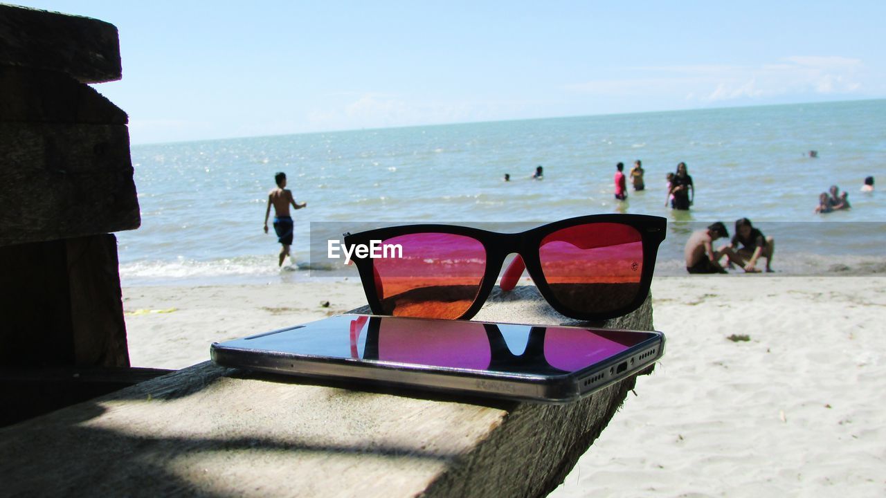 PEOPLE ON BEACH AGAINST SKY