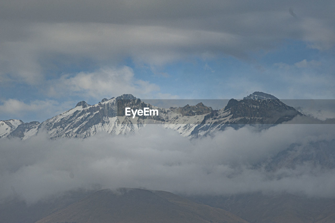 The chachani volcano seen in the middle of clouds that surround it in the city of arequipa