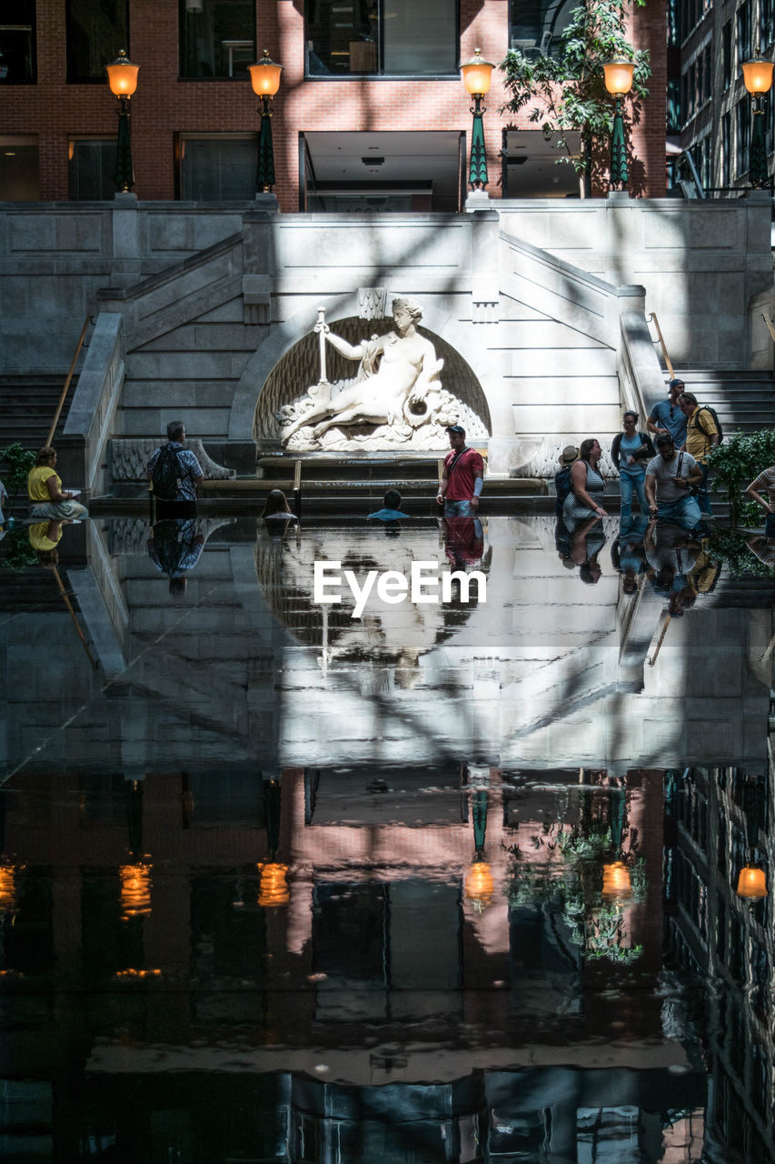 DIGITAL COMPOSITE IMAGE OF PEOPLE ON ILLUMINATED STREET