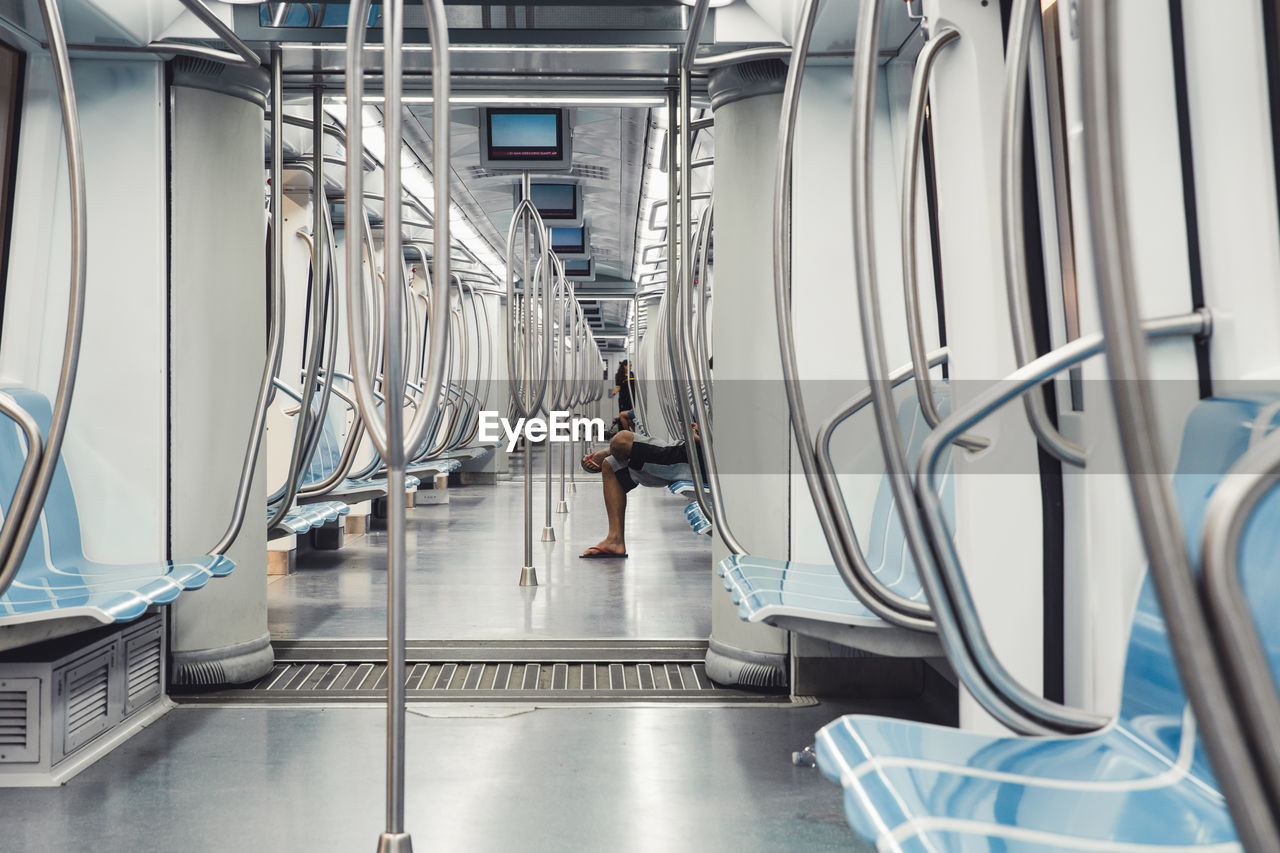 Low section of man sitting in train