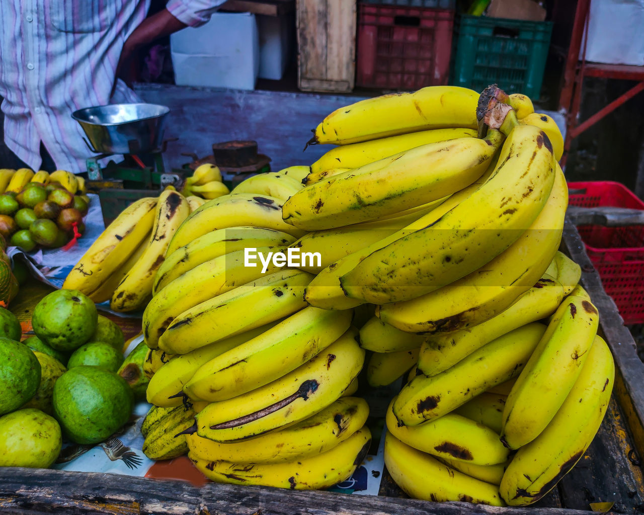 banana, healthy eating, food, cooking plantain, fruit, food and drink, wellbeing, freshness, produce, market, plant, yellow, retail, tropical fruit, abundance, business, market stall, adult, occupation, clothing, person, ripe, one person, bunch, outdoors, day, for sale, selling, city, business finance and industry, men
