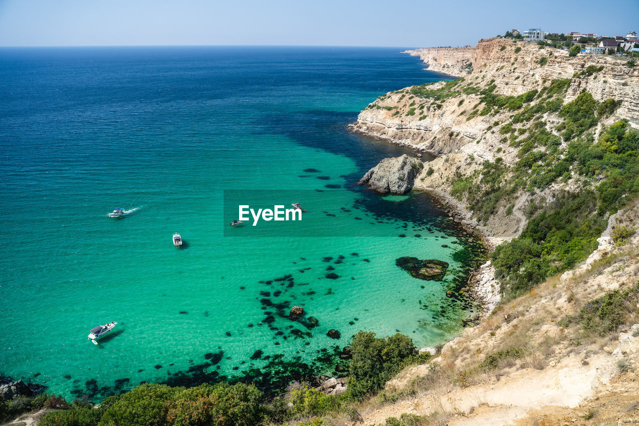 HIGH ANGLE VIEW OF BEACH AGAINST BLUE SKY