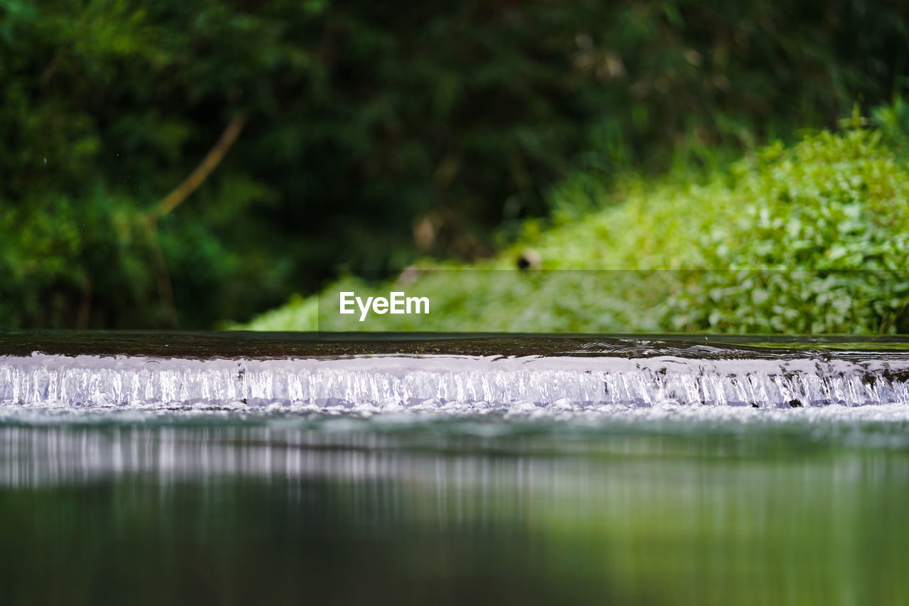 CLOSE-UP OF WATER SURFACE LEVEL OF LAND