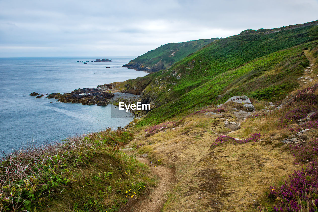 Scenic view of sea and mountains against sky