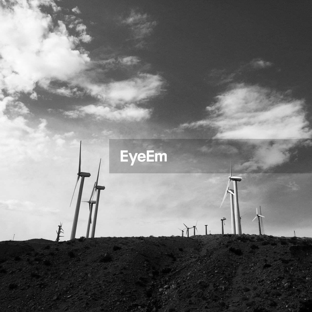 Wind turbines on field against sky