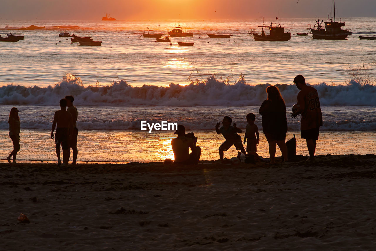 SILHOUETTE PEOPLE AT BEACH DURING SUNSET