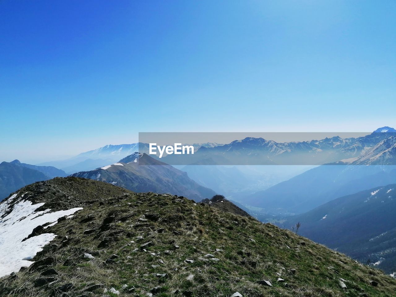 Scenic view of snowcapped mountains against clear blue sky