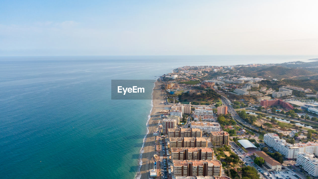 high angle view of city by sea against sky