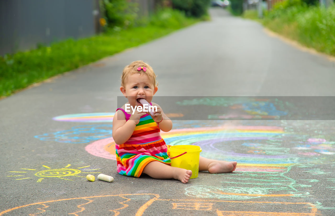 portrait of cute boy playing with toy on road