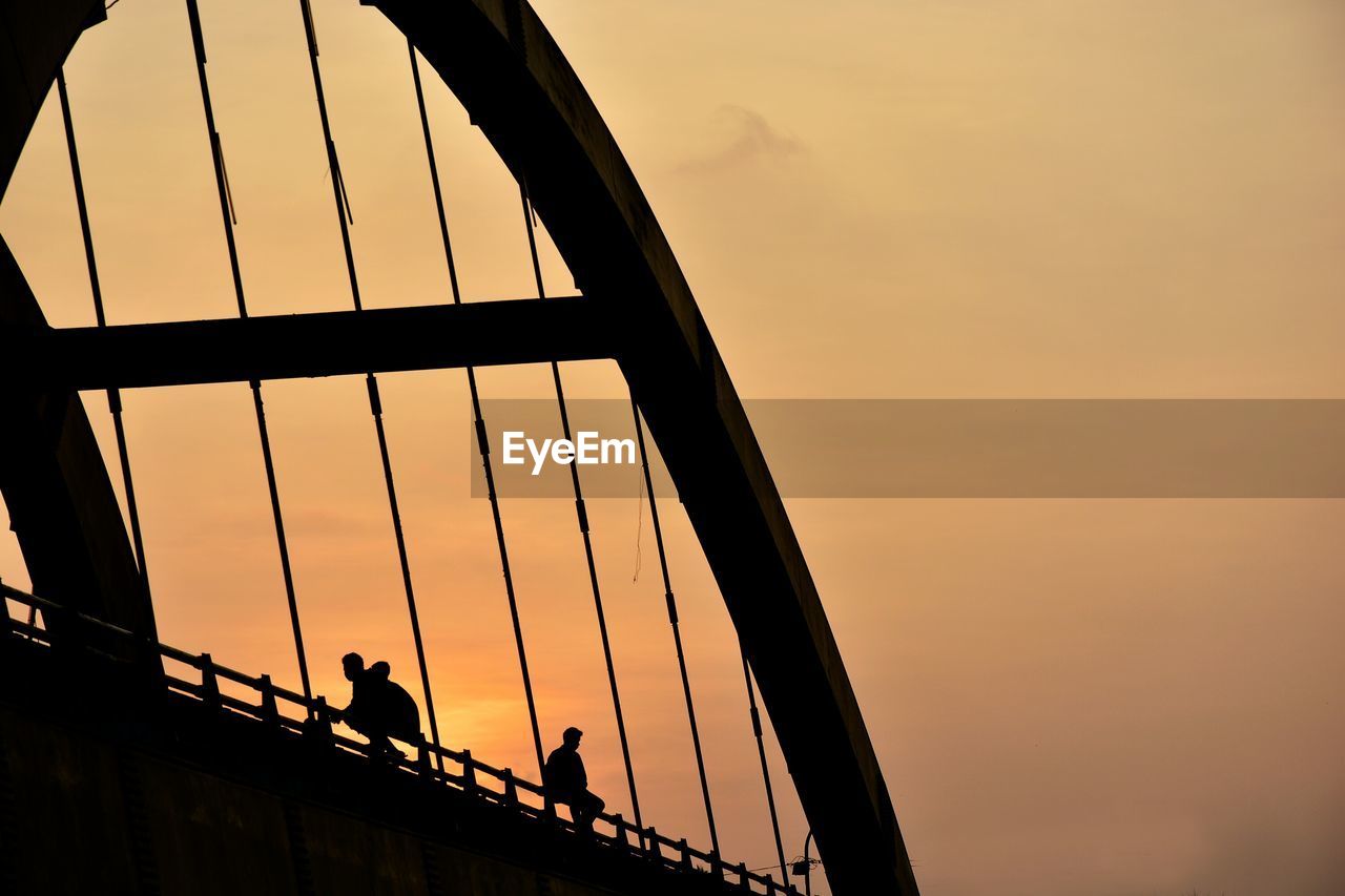 Low angle view of silhouette bridge against sky during sunset