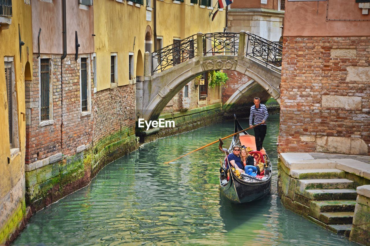 BRIDGE OVER CANAL AMIDST BUILDINGS