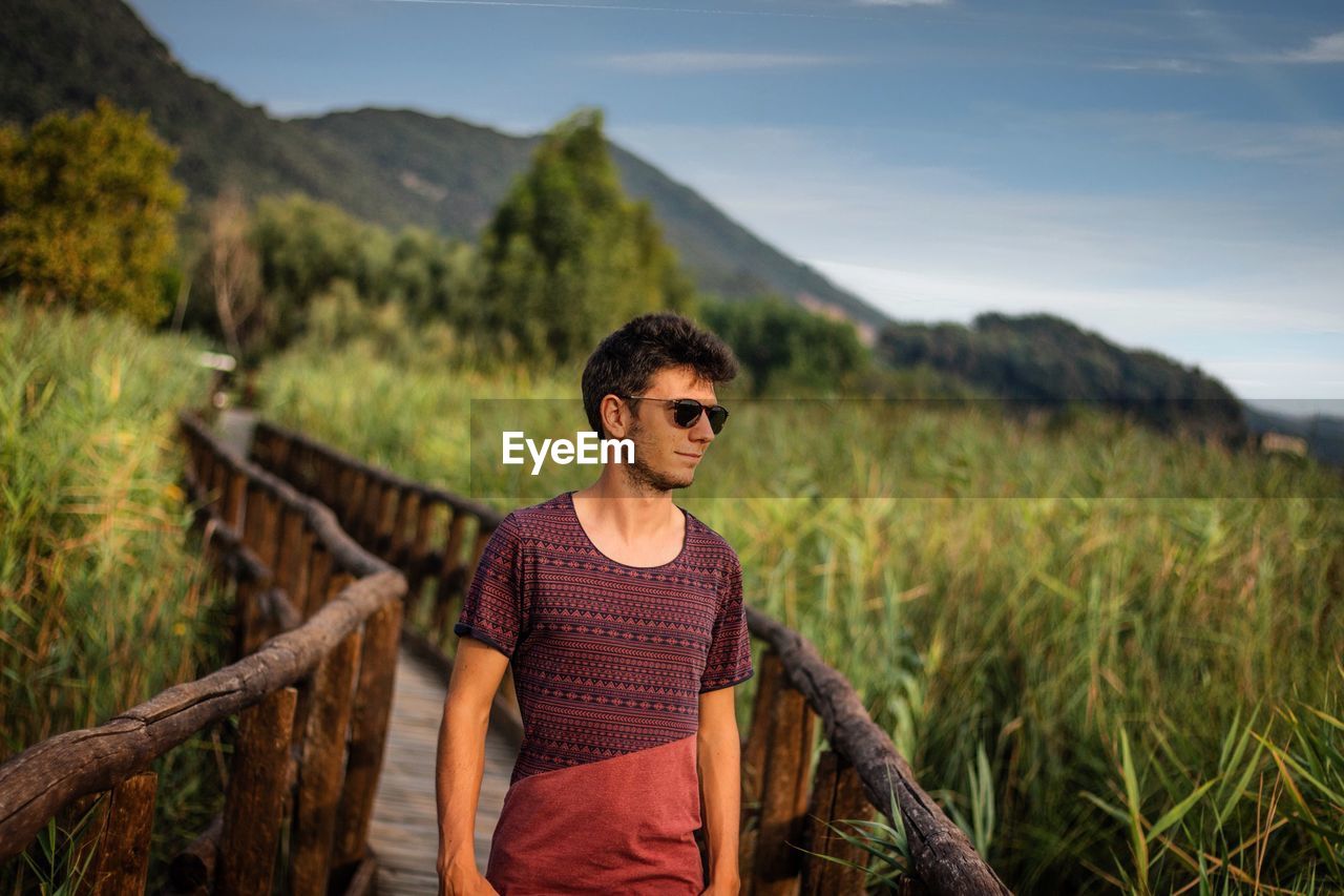 Young man standing on land against sky