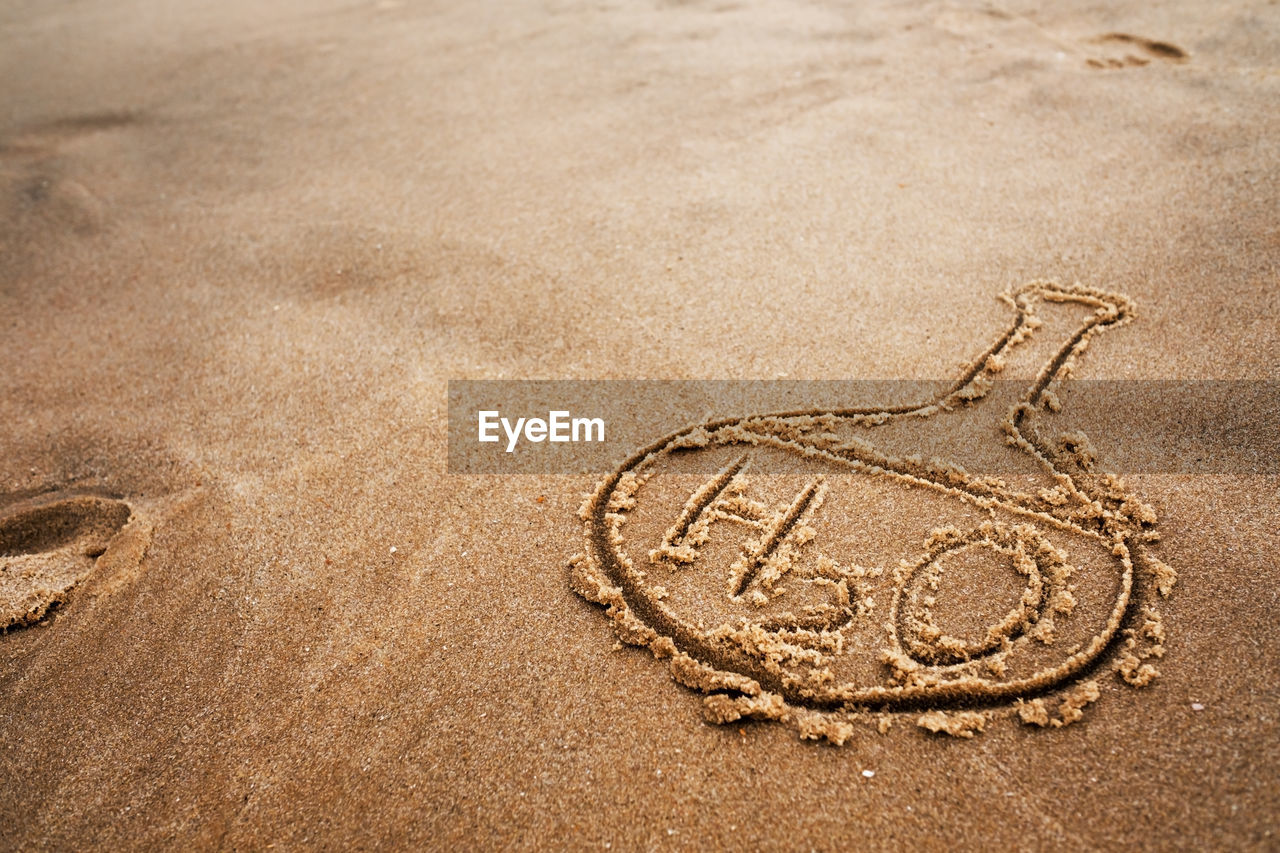 HIGH ANGLE VIEW OF OLD TEXT ON SAND