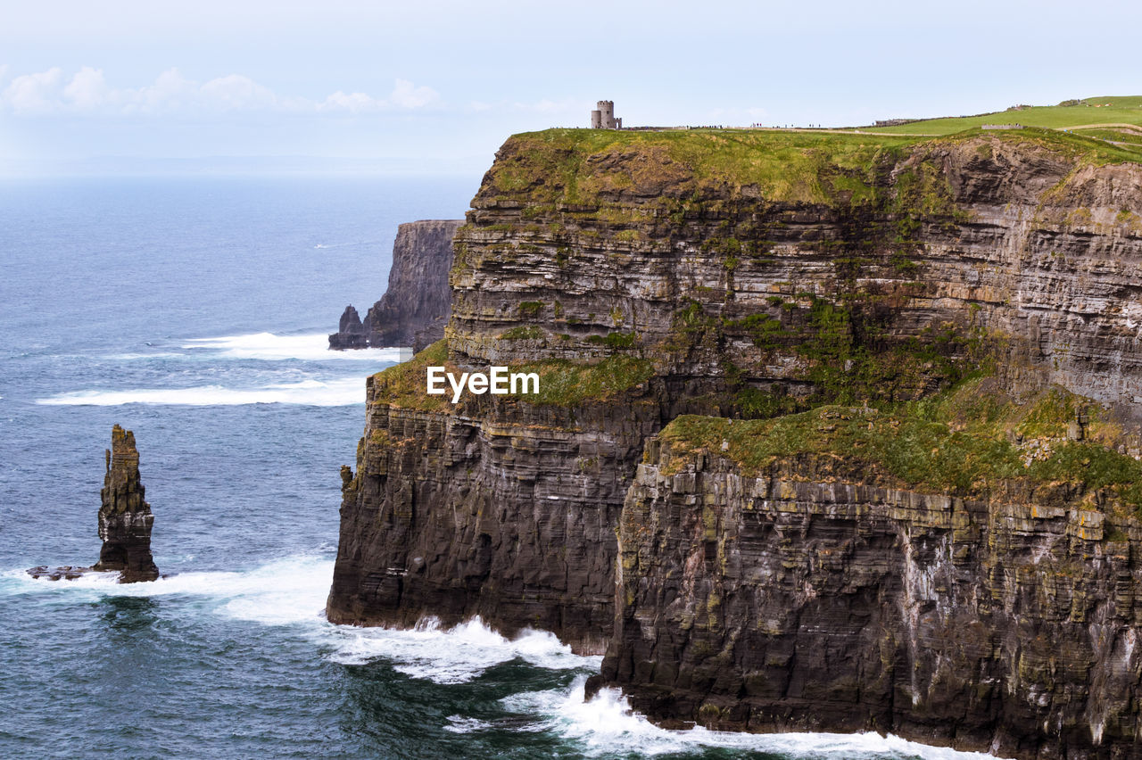 Rock formation by sea against sky