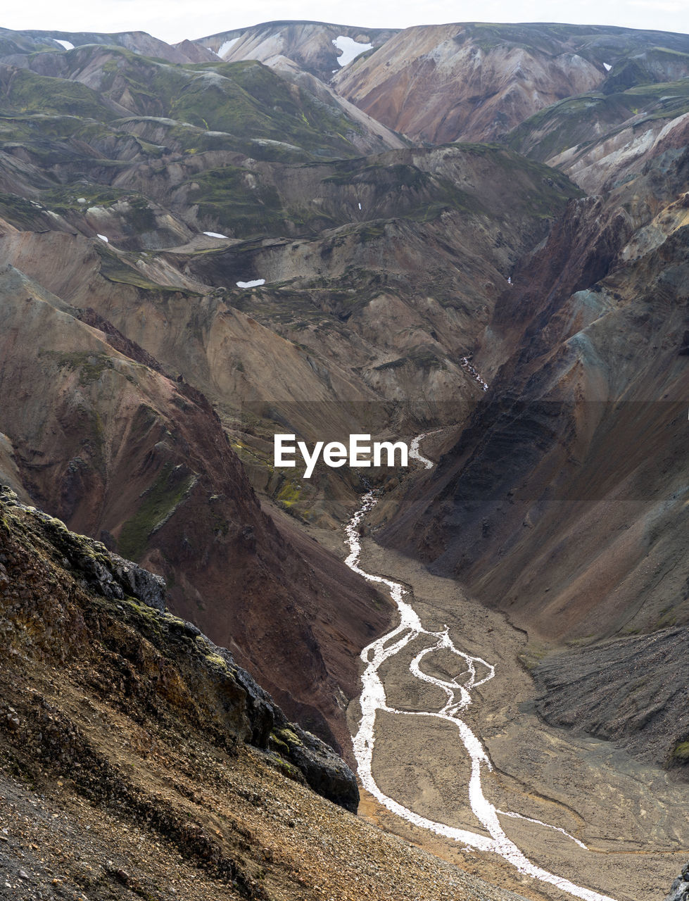 Creek is rushing down from melting snow patches in iceland's highlands