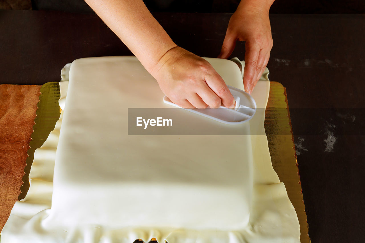 MIDSECTION OF PERSON HAVING FOOD AT TABLE