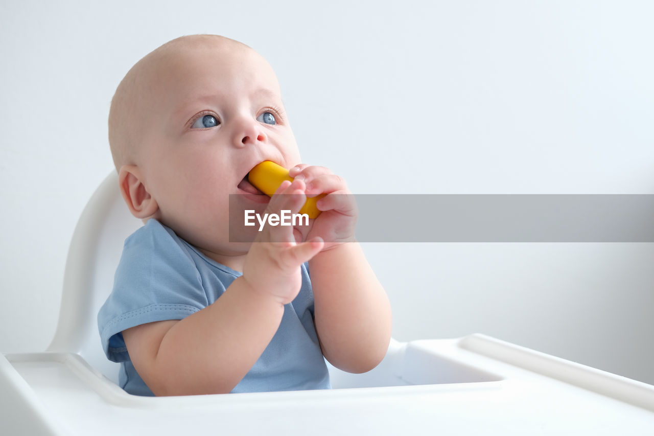 cropped hand of woman holding toy against white background