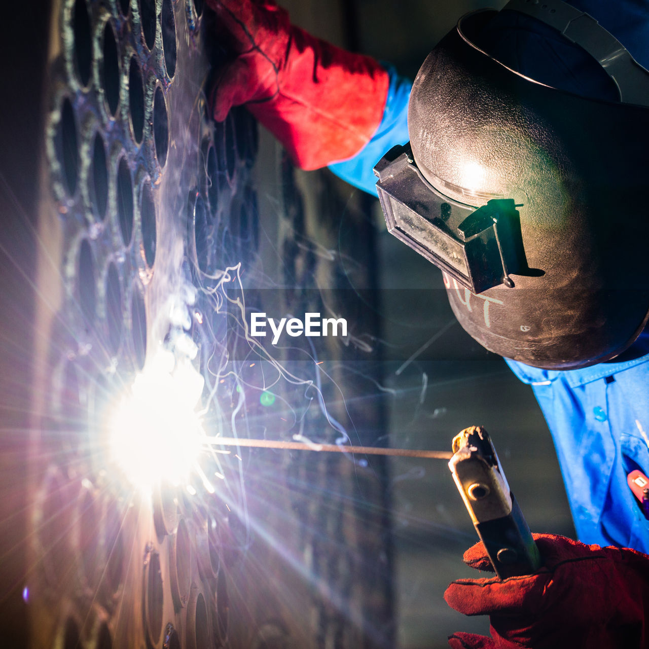 Close-up of man welding metal at night