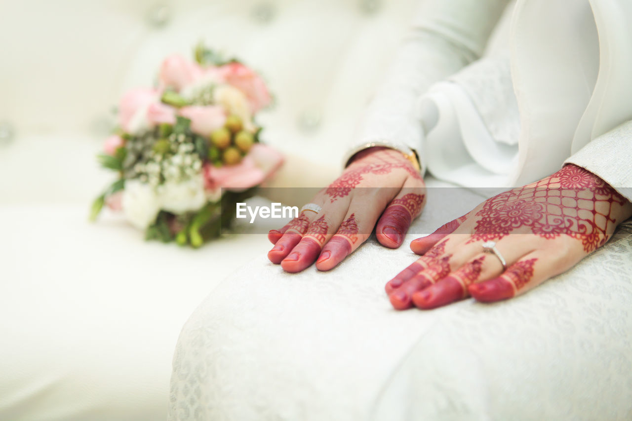 Henna tattoo on the bride's hand. heart shaped hand. with a wedding ring.
