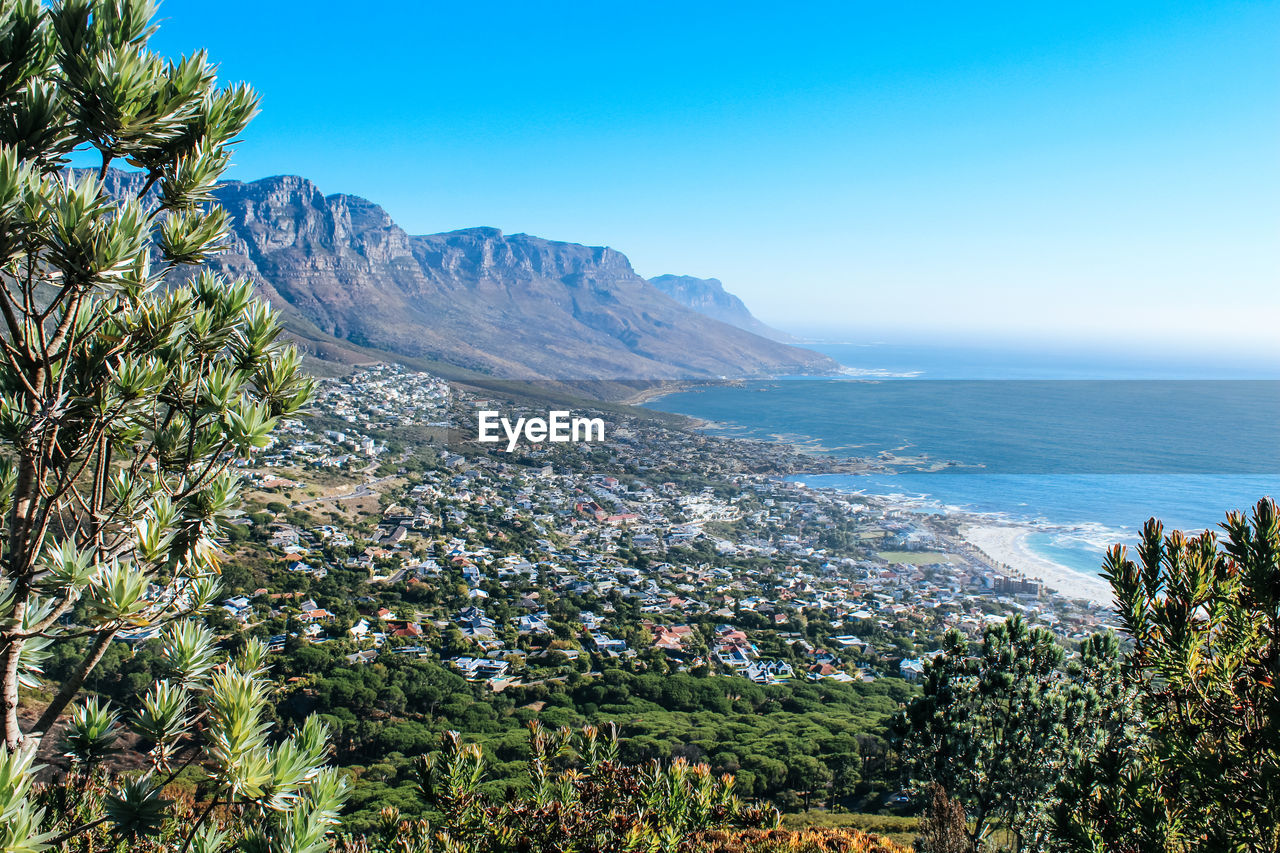 Scenic view of sea and mountains against clear sky