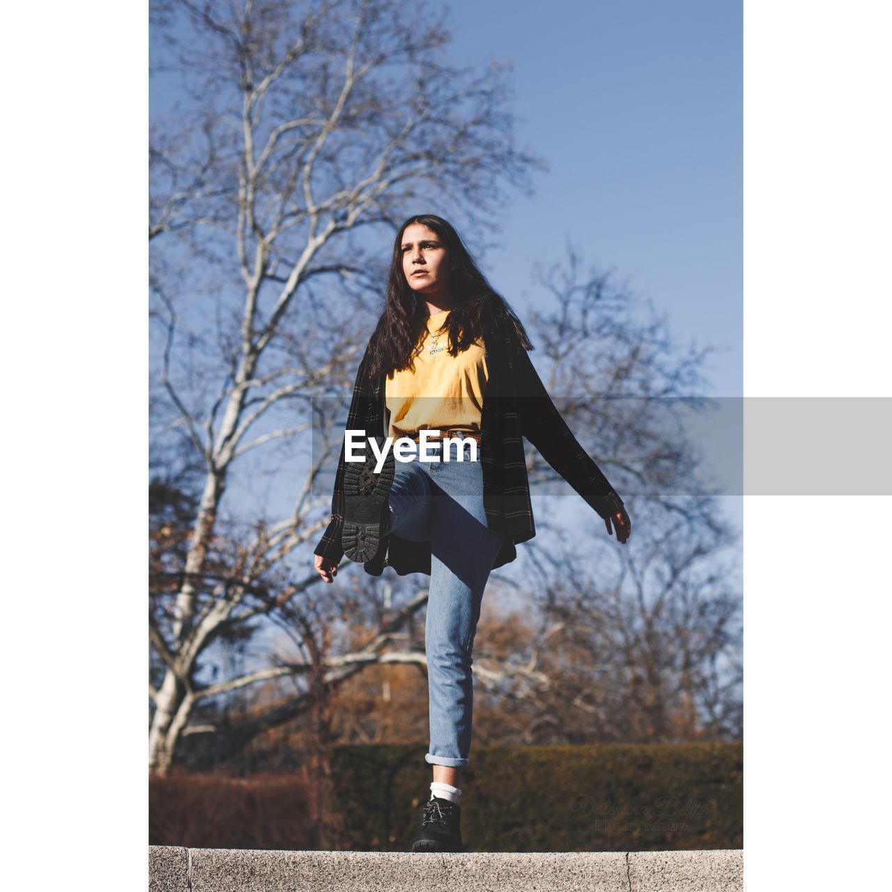 Low angle view of woman against bare trees at park