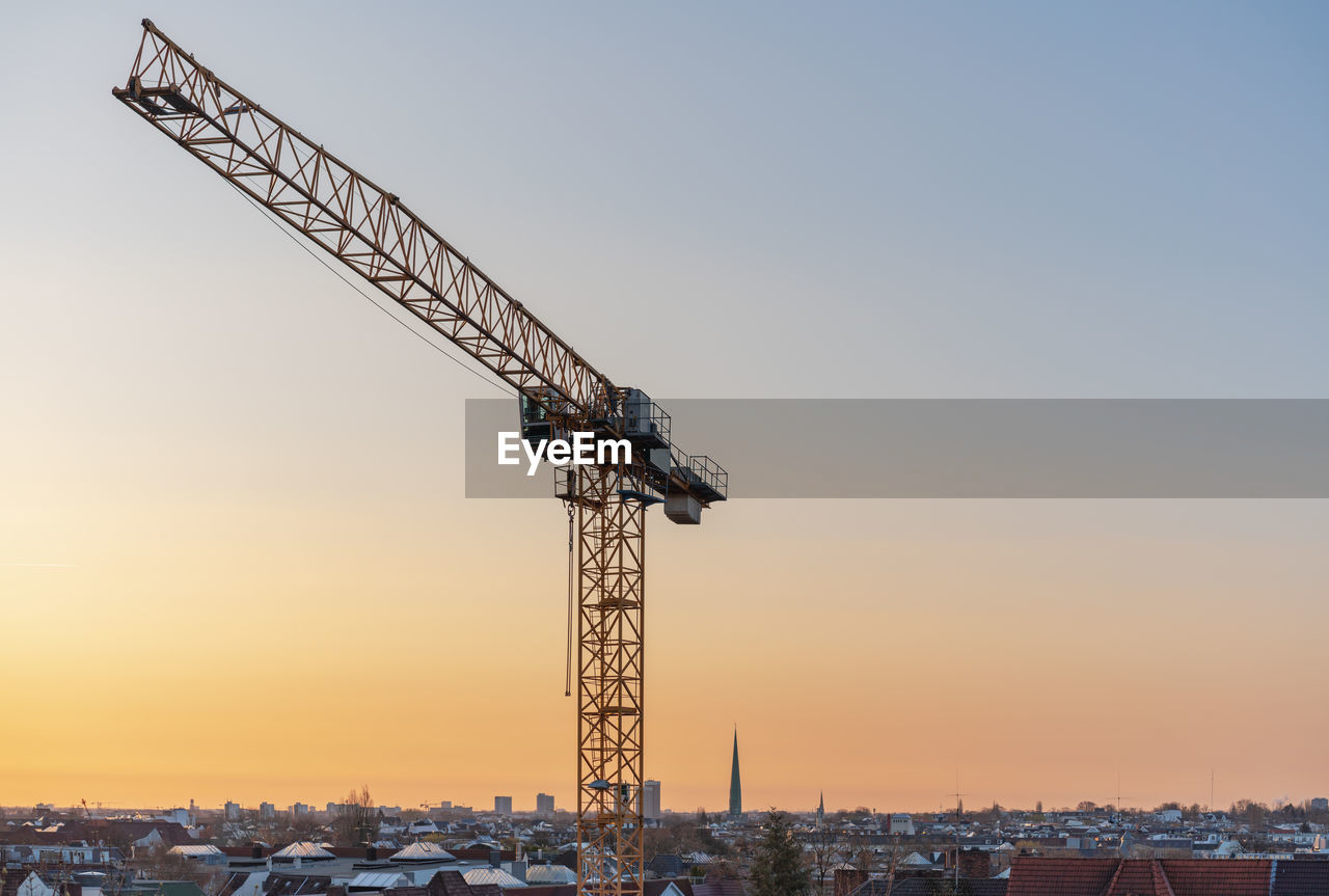 CRANE AT CONSTRUCTION SITE DURING SUNSET
