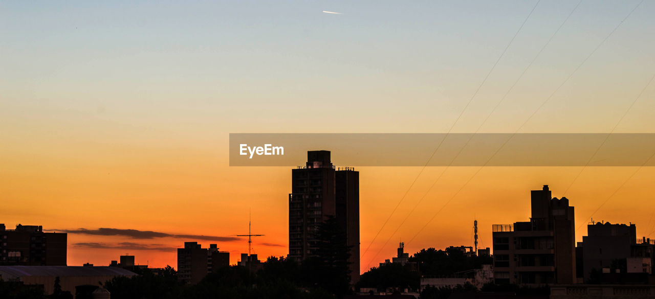 Silhouette buildings against sky during sunset