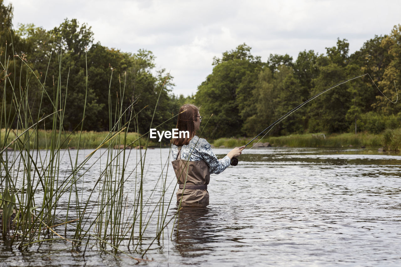 Woman fishing in lake