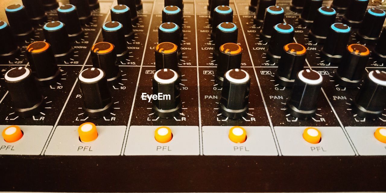 Close-up of analog audio mixer with funky colors