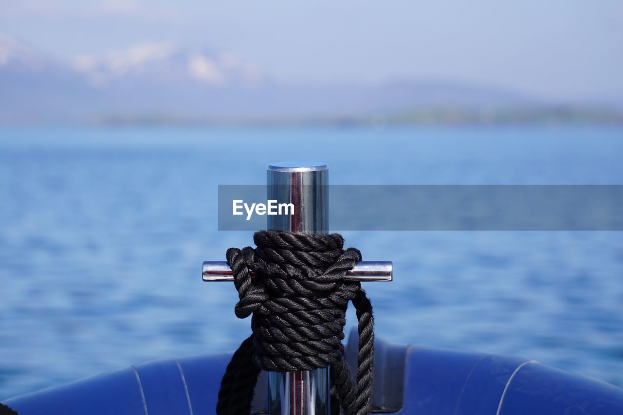 Close-up of black rope tied on boat in river