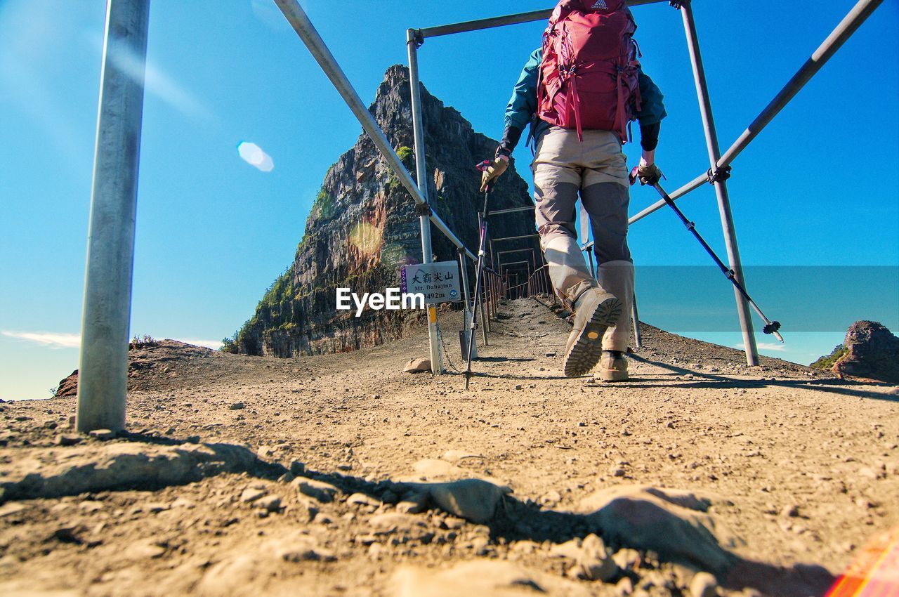 Rear view of woman on beach against clear sky