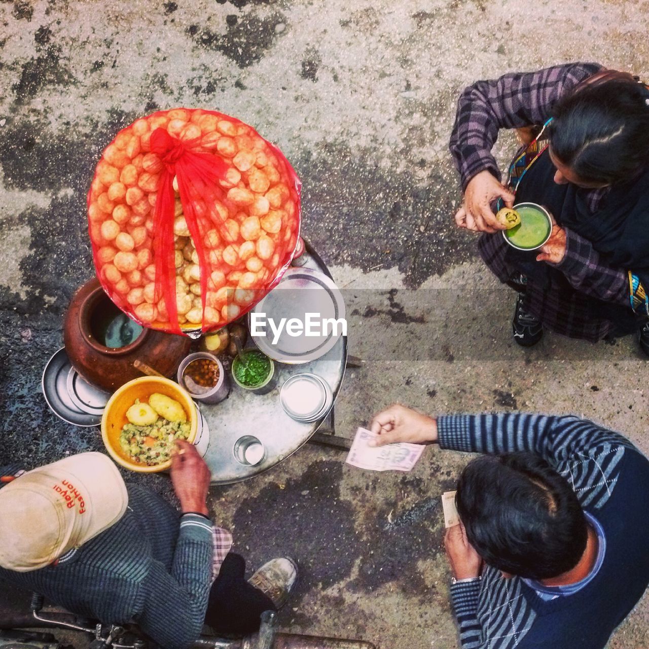 HIGH ANGLE VIEW OF PEOPLE SITTING WITH FOOD