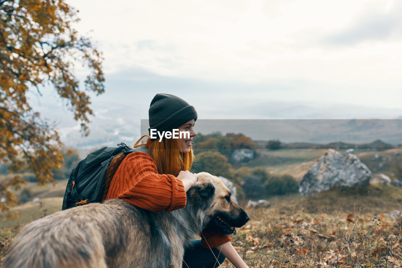 REAR VIEW OF MAN WITH DOG ON THE LAND