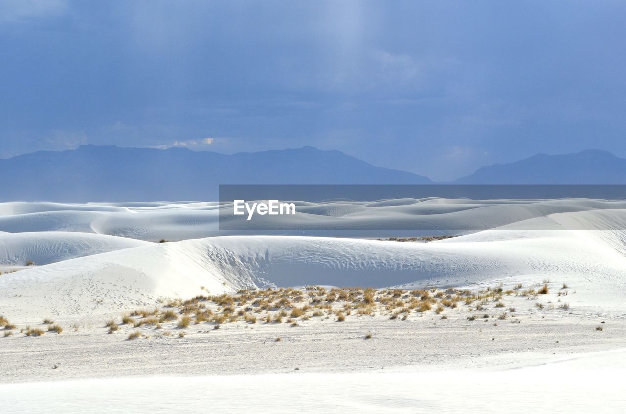 Scenic view of snow covered landscape against cloudy sky