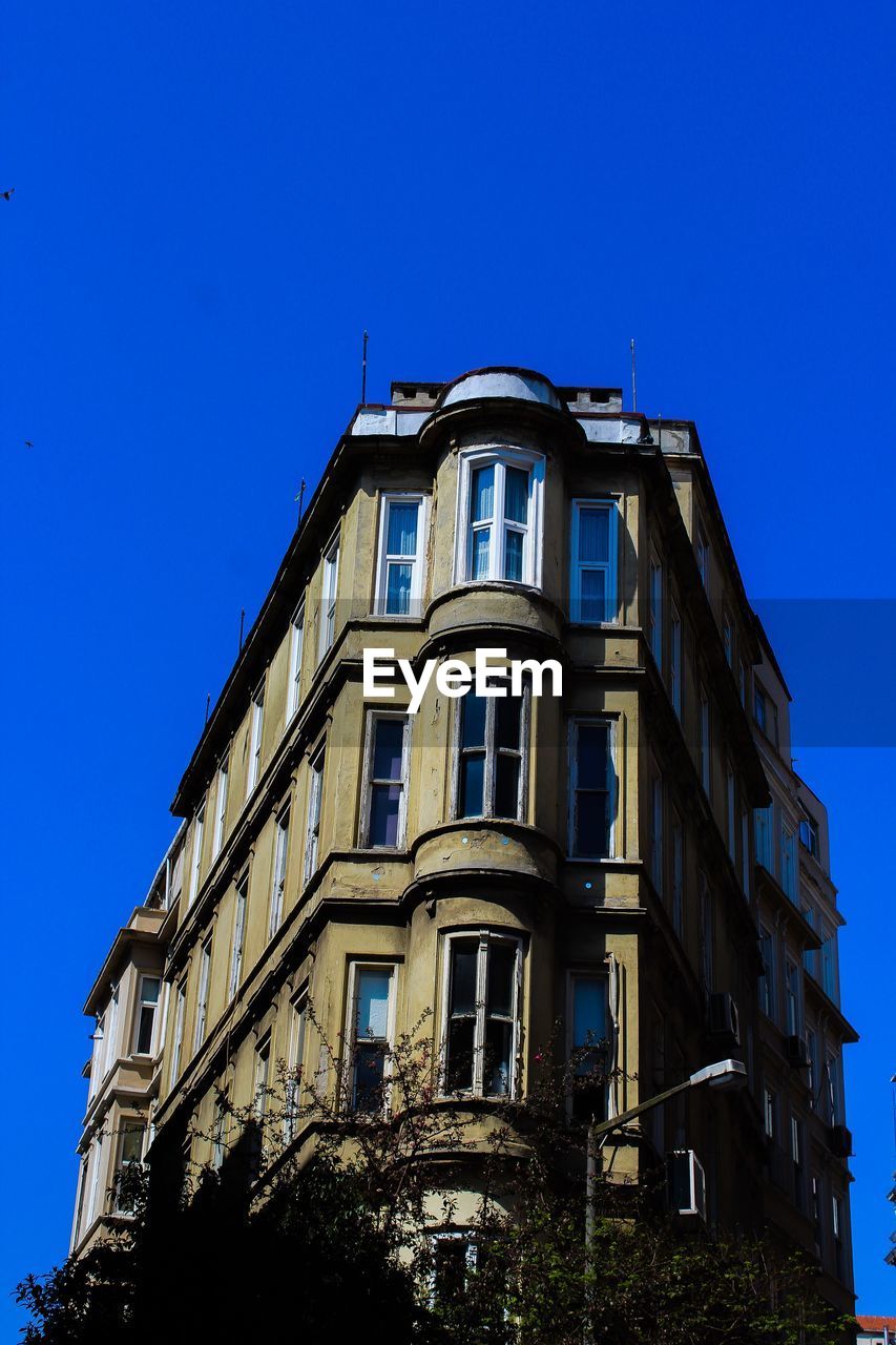 LOW ANGLE VIEW OF OLD BUILDING AGAINST BLUE SKY