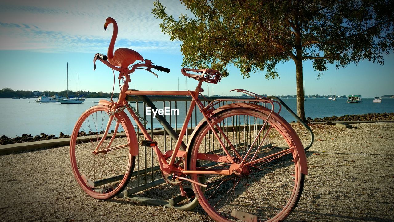 BICYCLE ON BEACH BY SEA AGAINST SKY